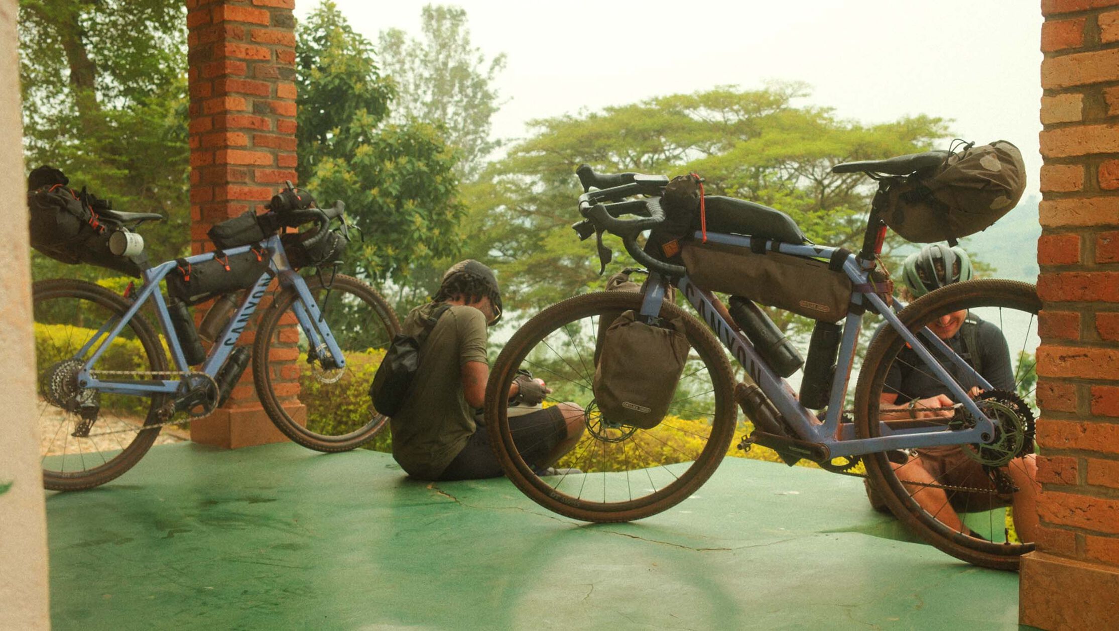 Twee Canyon gravelbikes, uitgerust met een complete bikepacking-uitrusting, inclusief frame-, stuur- en zadeltassen, rusten uit terwijl de rijders zich voorbereiden op het volgende deel van hun reis.